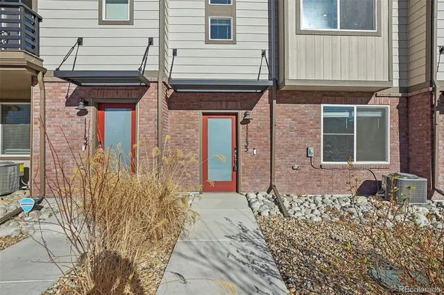 a large white kitchen with stainless steel appliances granite countertop a stove a sink a dining table and chairs with wooden floor