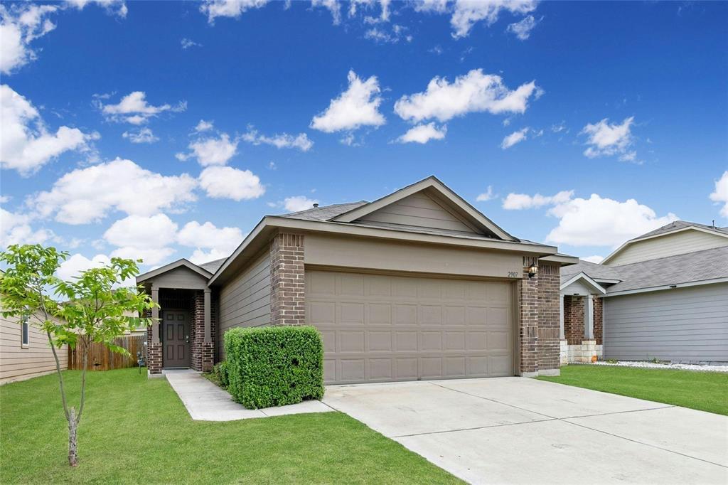 Single story home featuring brick siding, an attached garage, and concrete driveway