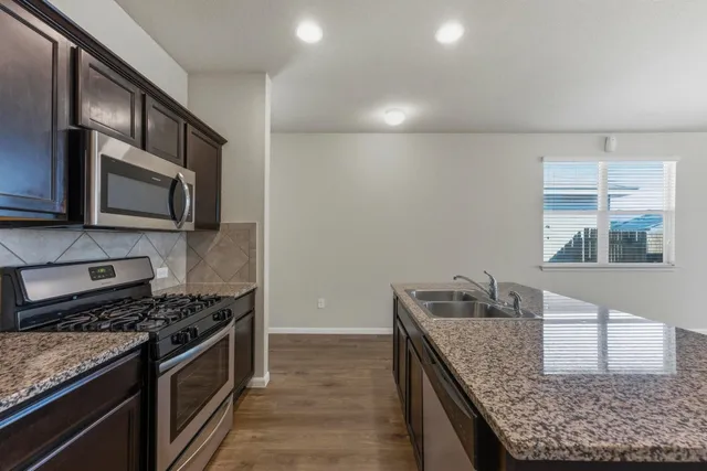 a kitchen with a sink cabinets and wooden floor