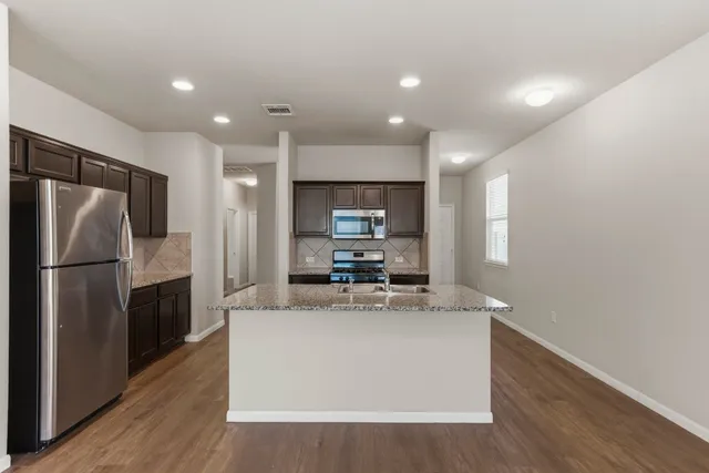 a view of a kitchen with a sink and refrigerator