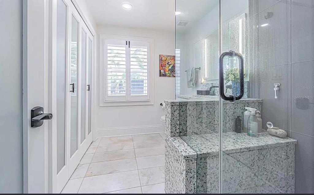 1175 Jackson Road Clearwater, FL 33755 - Photo 15 of 23 a bathroom with a granite countertop sink a mirror and shower