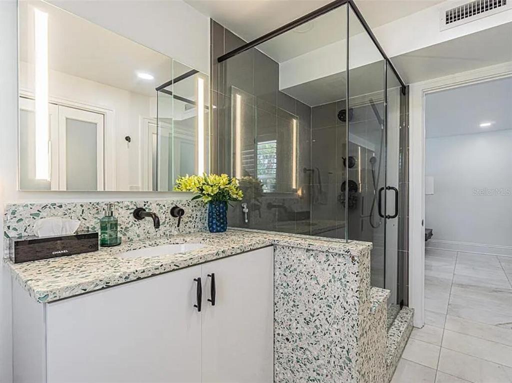 1175 Jackson Road Clearwater, FL 33755 - Photo 17 of 23 a bathroom with a granite countertop sink a mirror and a shower