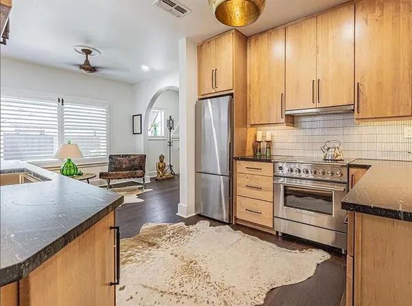 a kitchen with stainless steel appliances granite countertop a sink and a window