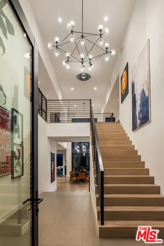 a dining room with wooden floor and white kitchen view