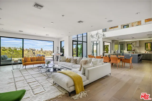 a view of a dining room with furniture a chandelier and wooden floor