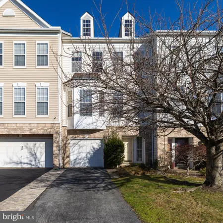 a view of a brick house with many windows next to a road
