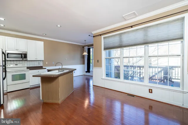 a kitchen with stainless steel appliances granite countertop a refrigerator a sink dishwasher and a stove with wooden floor