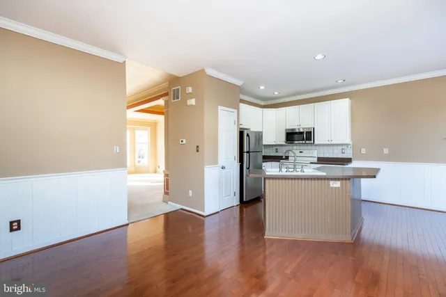 a kitchen with kitchen island a counter top space cabinets and stainless steel appliances