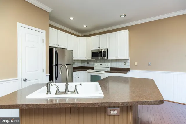 a kitchen with stainless steel appliances granite countertop a sink a refrigerator and a stove