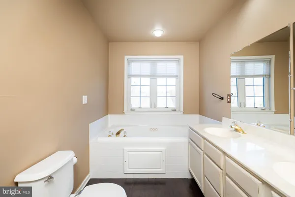 a bathroom with a tub sink and mirror