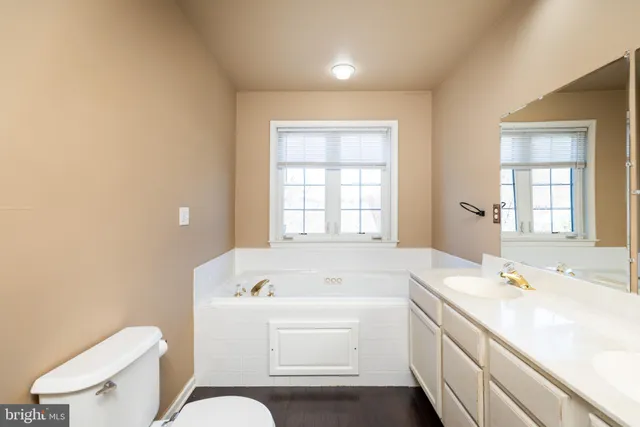 a bathroom with a tub sink and mirror