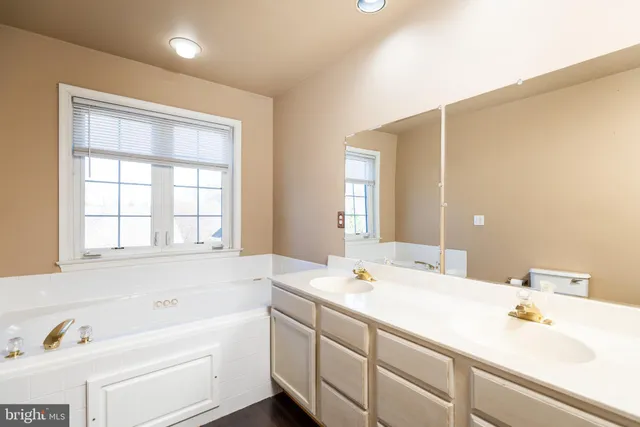 a spacious bathroom with a shower sink and mirror