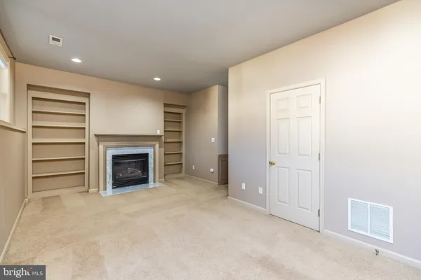 an empty room with a fireplace and cabinet