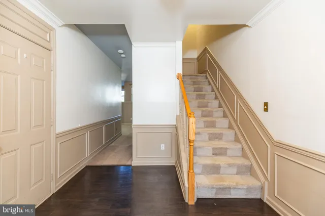 a view of a staircase and white walls with wooden floor