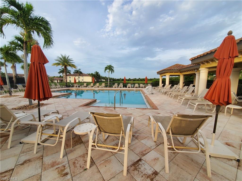 9521 Avellino Way, Unit 2415 Naples, FL 34113 - Photo 13 of 48 a view of a swimming pool with a table and chairs