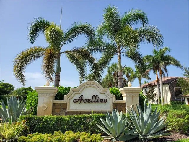 a view of a white house with a yard and a palm tree
