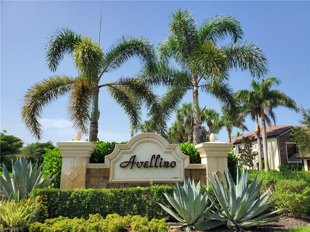 9521 Avellino Way, Unit 2415 Naples, FL 34113 - Photo 20 of 48 a view of a white house with a yard and a palm tree