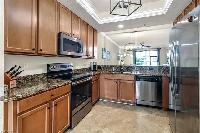 a kitchen with stainless steel appliances granite countertop a stove a sink and a microwave