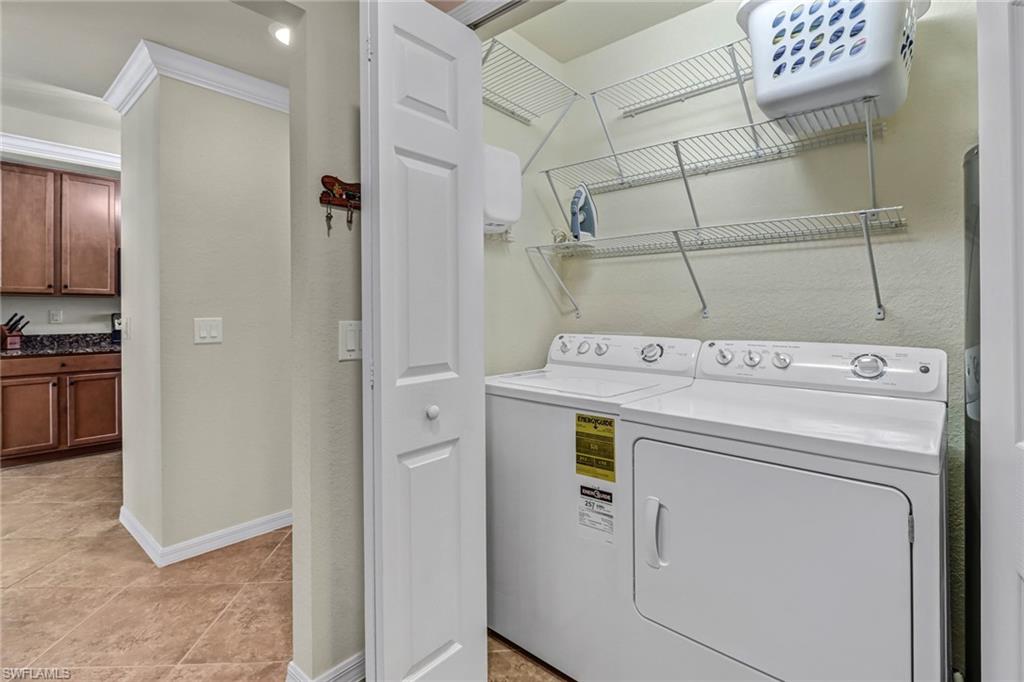 9521 Avellino Way, Unit 2415 Naples, FL 34113 - Photo 30 of 48 a view of washer and dryer with kitchen in the background