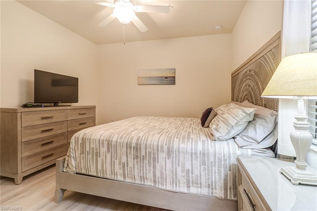 9521 Avellino Way, Unit 2415 Naples, FL 34113 - Photo 39 of 48 a bedroom with a bed and a flat screen tv