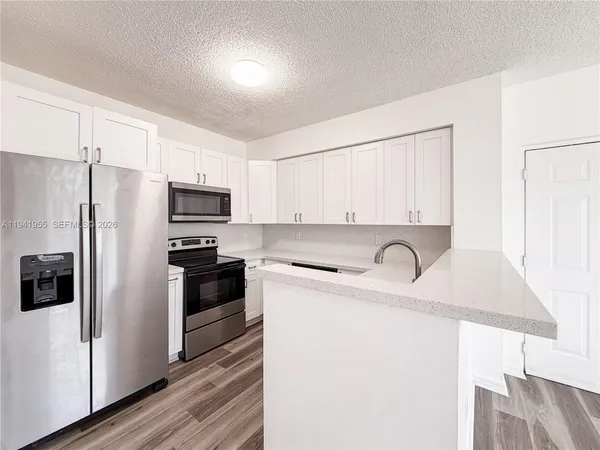 a kitchen with stainless steel appliances a refrigerator sink and microwave