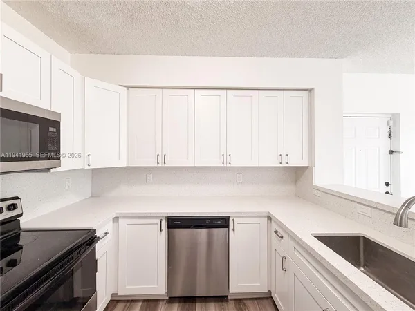 a kitchen with a sink cabinets and stainless steel appliances