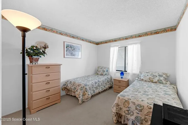 a bedroom with two beds and a potted plant