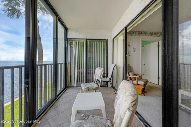 a view of a balcony with chair and floor to ceiling window