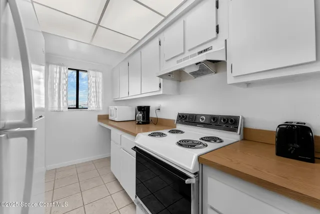 a kitchen with stainless steel appliances a stove a sink and white cabinets