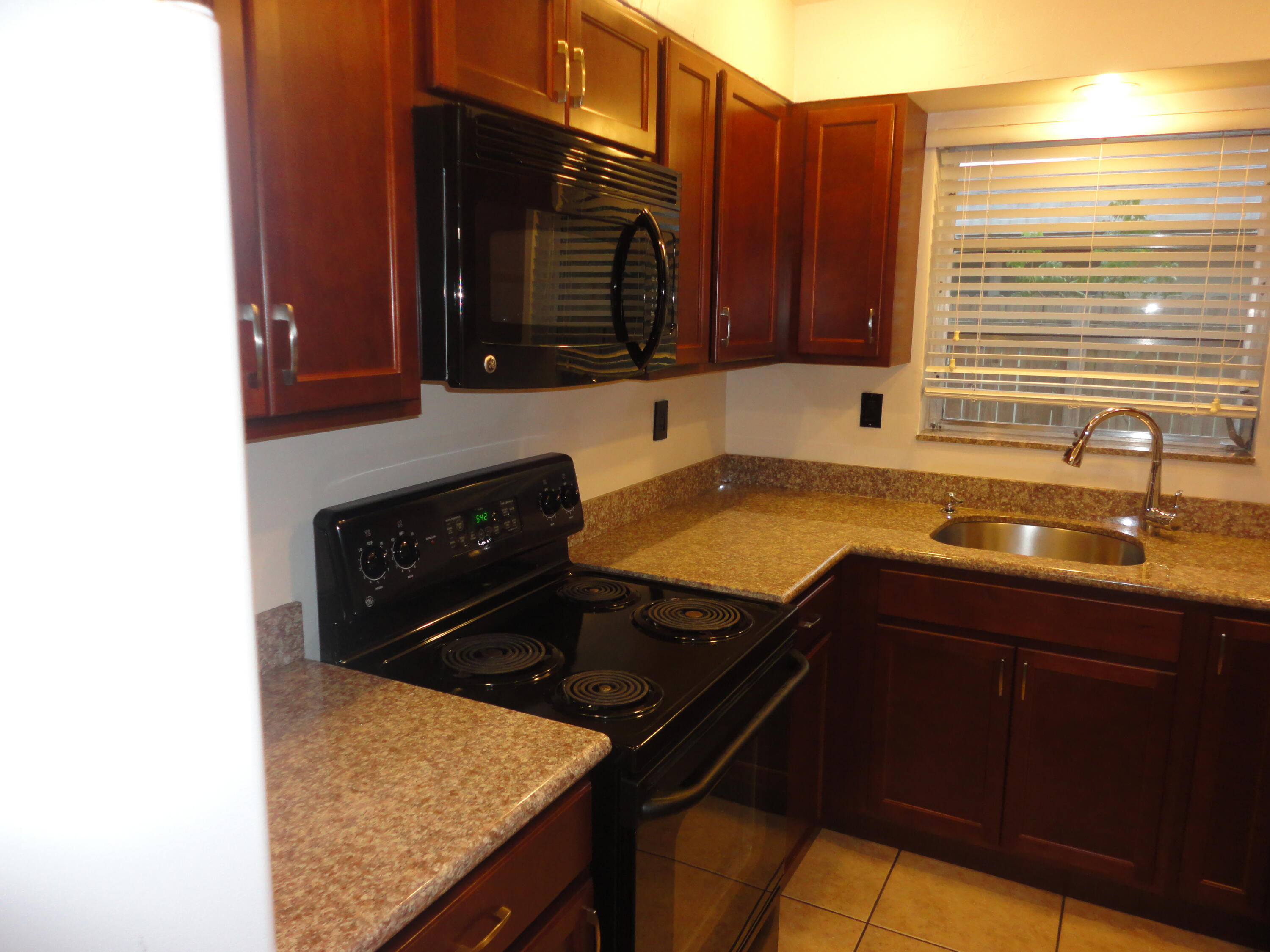 500 Northeast 28th Street Boca Raton, FL 33431 - Photo 5 of 10 a kitchen with a sink a stove and cabinets