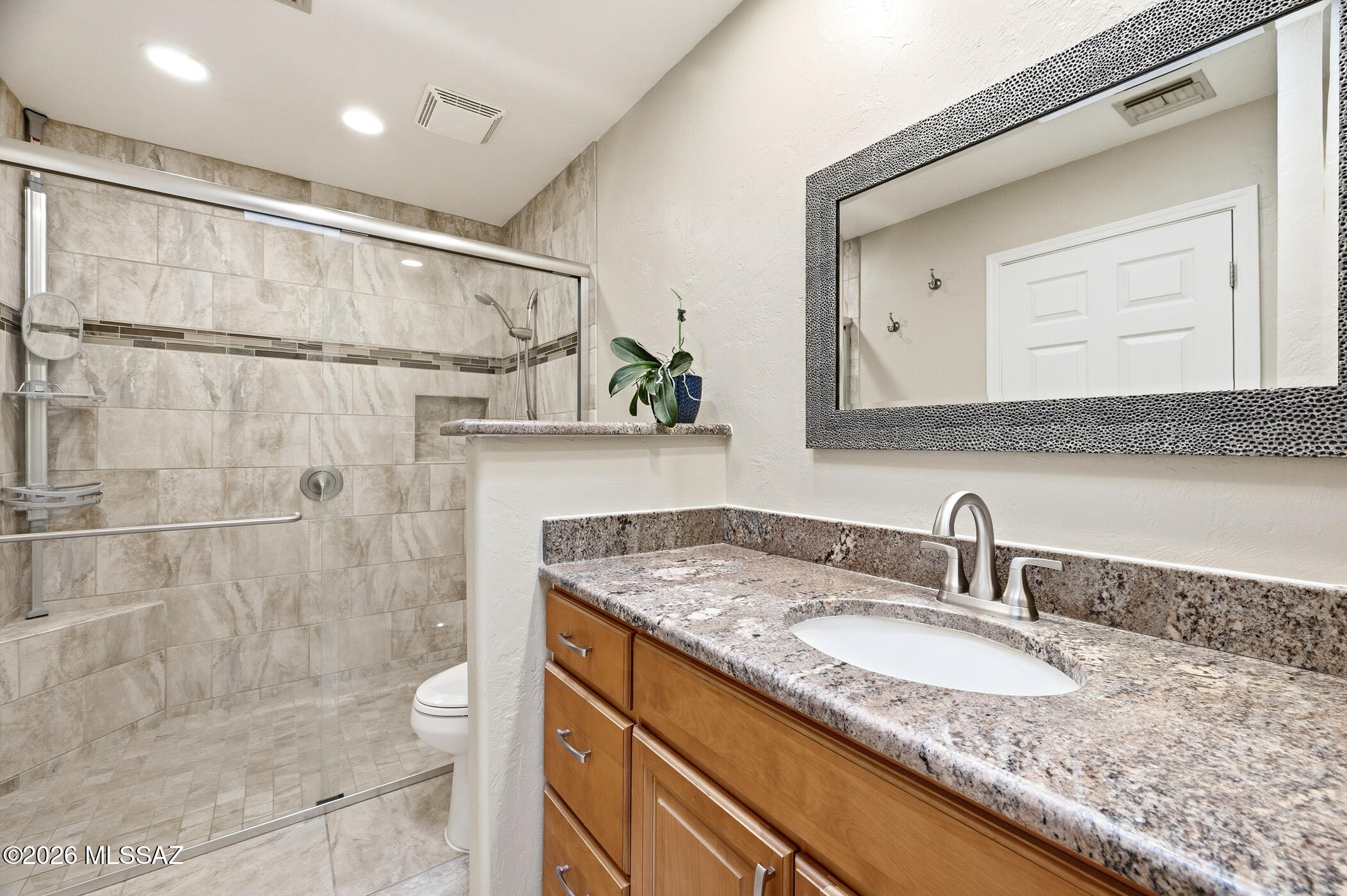 13599 East Rincon Ranch Road Vail, AZ 85641 - Photo 26 of 41 a bathroom with a granite countertop sink a mirror and shower