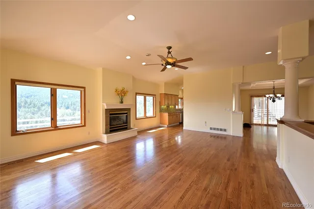 a view of an empty room with a fireplace and wooden floor