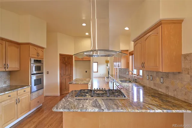 a kitchen with stainless steel appliances granite countertop a stove a sink and a refrigerator