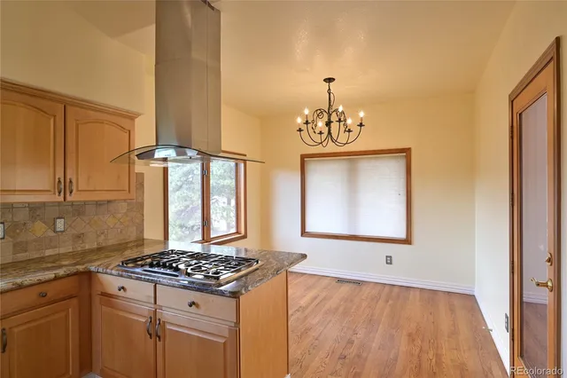 a kitchen with granite countertop a sink stove and refrigerator