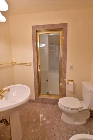 a bathroom with a toilet a sink and shower