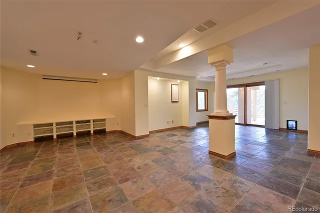 a view of a living room with a gaming machine and wooden floor