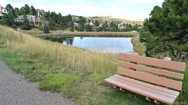 a view of a lake with a yard and large trees