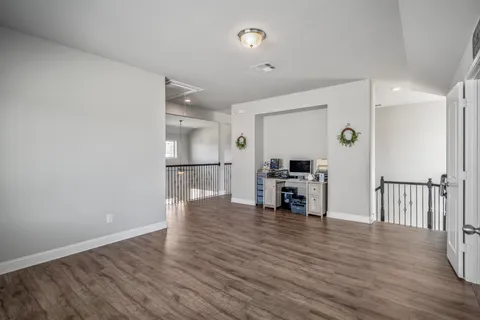 an empty room with wooden floor and a window