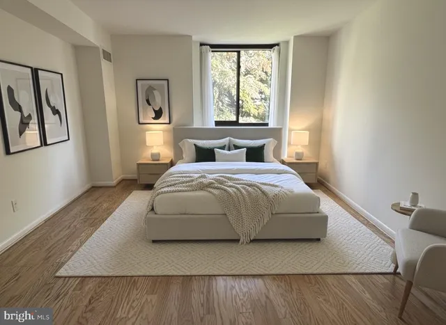 a bedroom with a bed lamp on table and a window