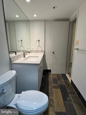 a bathroom with a sink a toilet a mirror and vanity