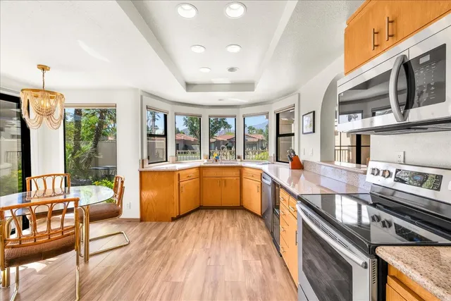 a large kitchen with stainless steel appliances granite countertop a lot of counter space and wooden floors