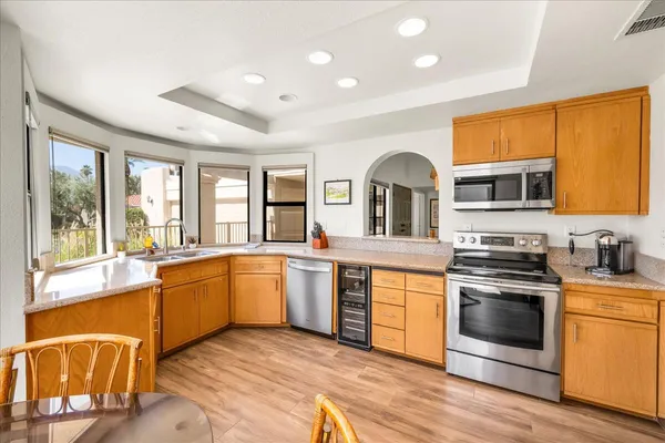 a large kitchen with stainless steel appliances granite countertop a stove and a sink
