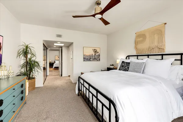 a spacious bedroom with a bed and a potted plant