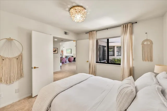 a bedroom with a bed and a chandelier