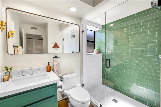 a bathroom with a sink mirror toilet and shower