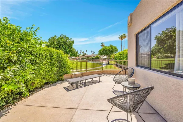 a swimming pool with outdoor seating and plants