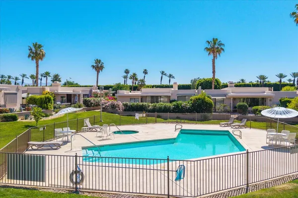 a view of a swimming pool and lounge chairs