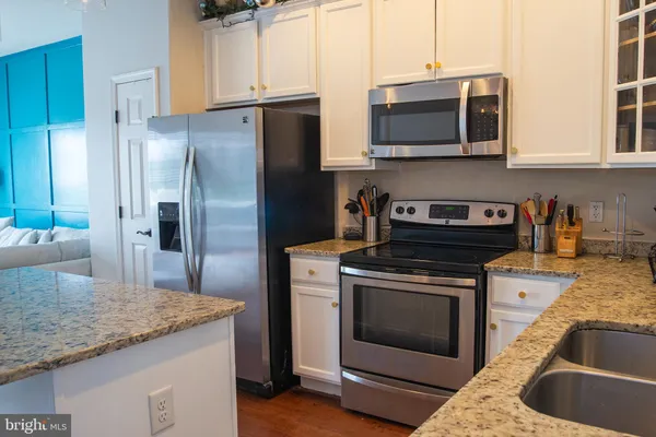 a kitchen with granite countertop a center island stainless steel appliances cabinets and a center island