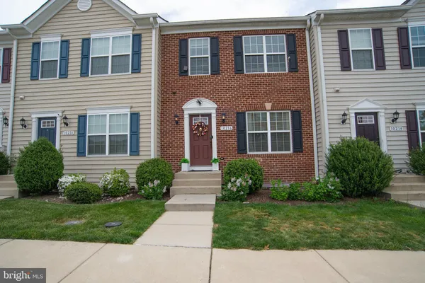 a view of a brick house with a yard next to a large window