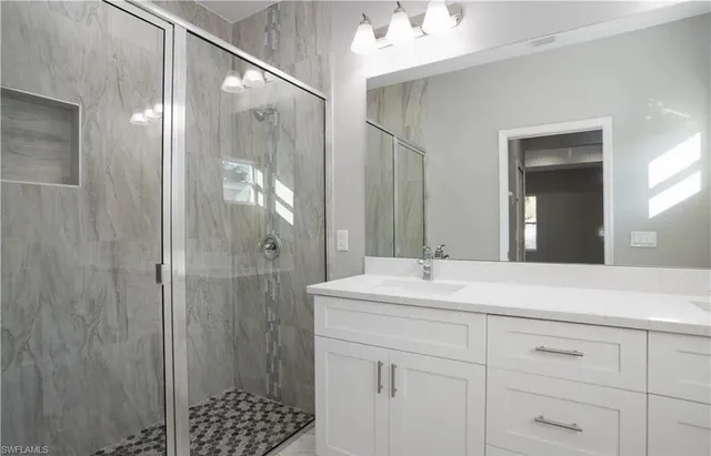 a bathroom with a shower sink and mirror